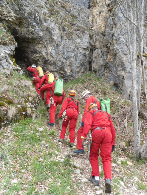 6 spéléologues se suivent en direction de l'entrée de la grotte